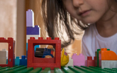 A little girl finding a hidden character in her duplo bricks. 