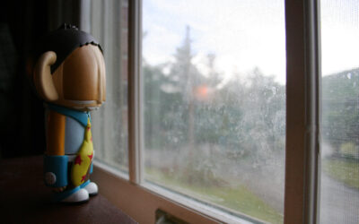 Depression hurts. Toy looking out a raining window.